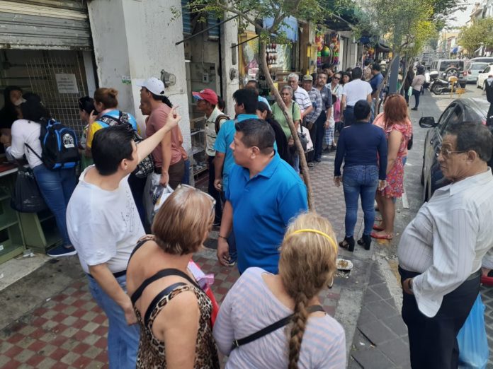 Se realiza larga fila de más de 120 clientes para comprar alcohol, en el centro de la ciudad